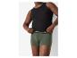 Man toont zwart tanktop en groene boxershorts.