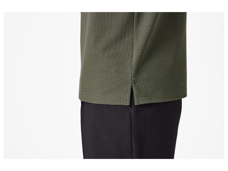 Detail van de onderzoom van een groen T-shirt met zijsplitten.