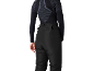 Vrouw van achteren in zwart thermoshirt en zwarte skibroek.