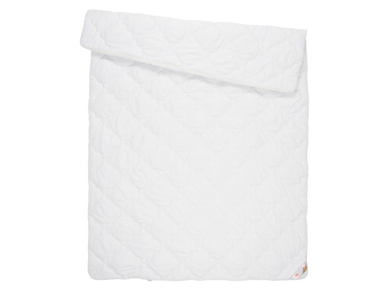 Een wit, gestikt dekbed, opgevouwen.