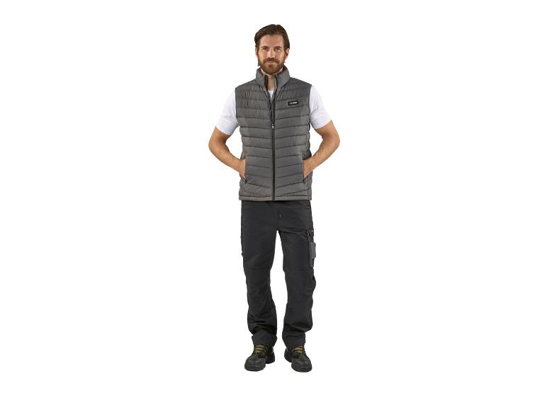 Man draagt een grijze Parkside puffer vest, zwarte werkbroek en zwarte schoenen.