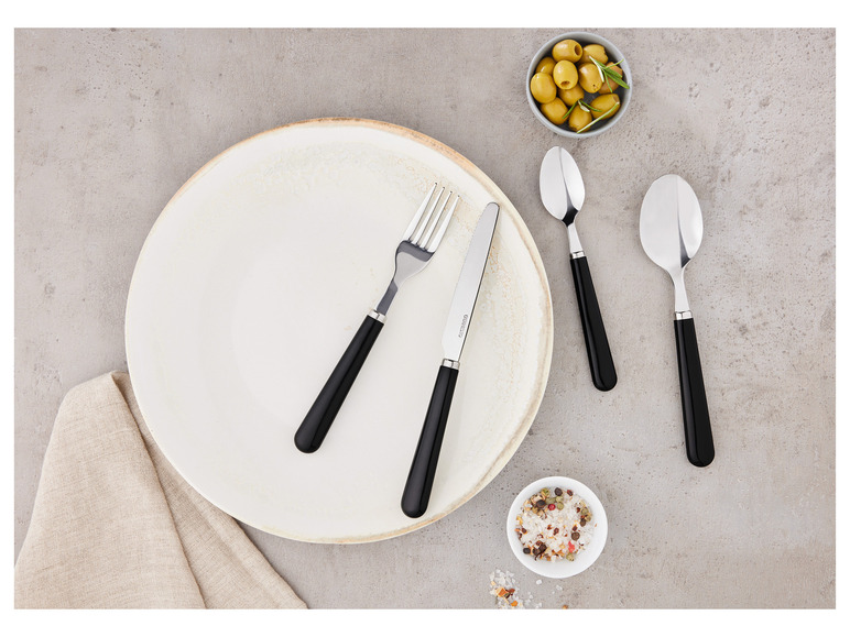 Een wit bord met zwart bestek, inclusief een mes van Ernesto.