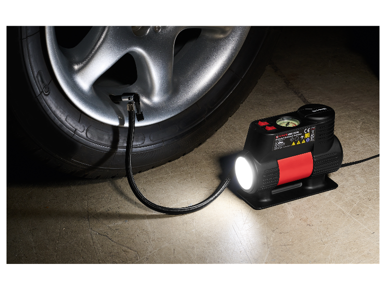 Ultimate UMK 10 E4 compressor met LED-lamp, aangesloten op een auto.