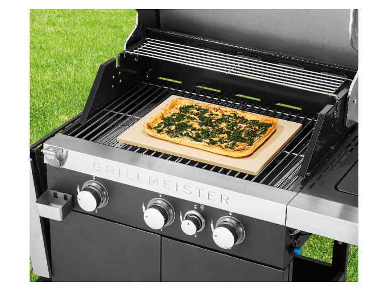 Barbecue met pizza op baksteen, buiten op het gras