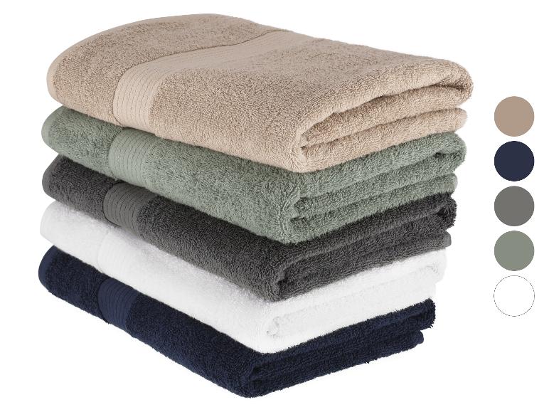 Een stapel badlakens in verschillende kleuren.