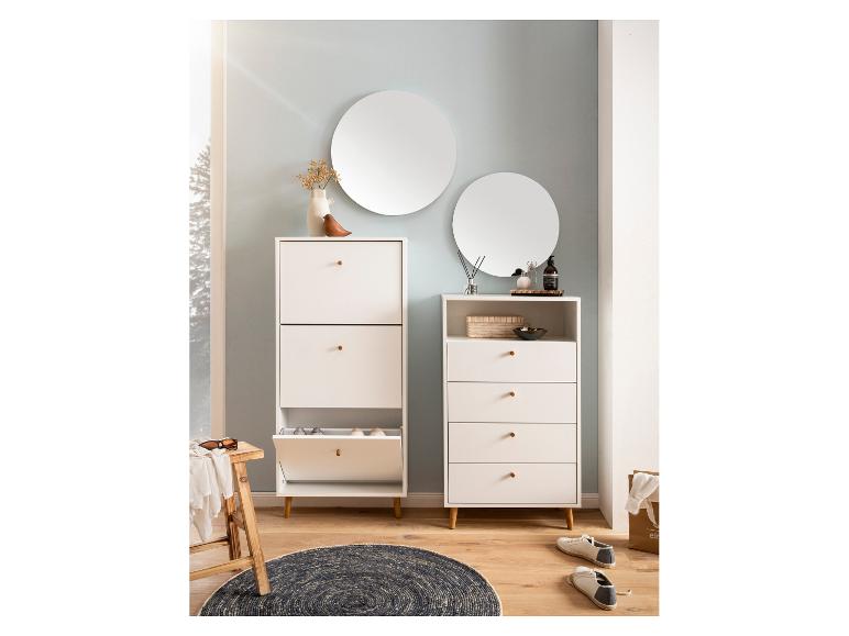 Witte halmeubels met houten accenten, inclusief schoenenkast, ladekast en ronde spiegels.