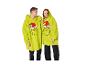 Twee mensen dragen oversized Grinch-hoodiedekens.