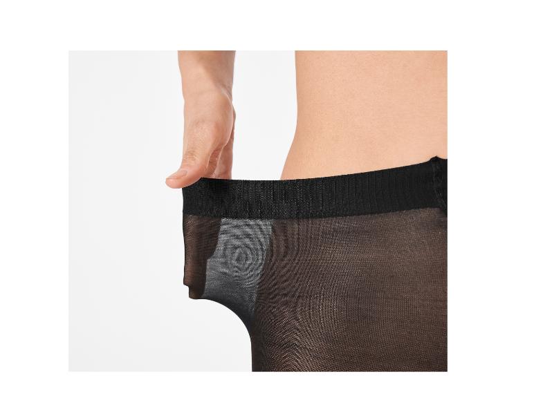 Vrouw rekt de tailleband van een doorschijnende zwarte panty uit
