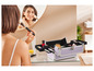 Een vrouw doet make-up aan voor de spiegel met een make-upkoffer.