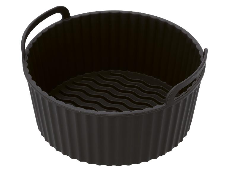 Zwarte siliconen airfryer mand met golvende bodem en handvatten.