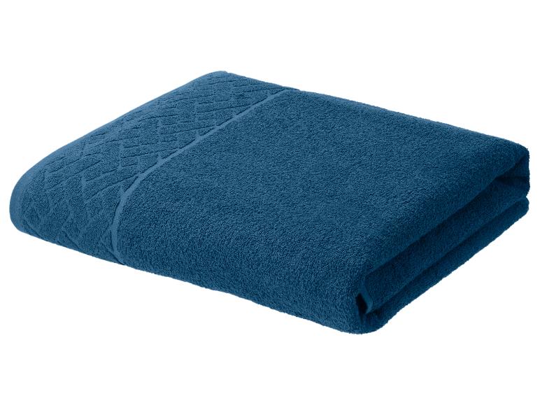 Gevouwen, marineblauwe katoenen handdoek met een decoratief patroon