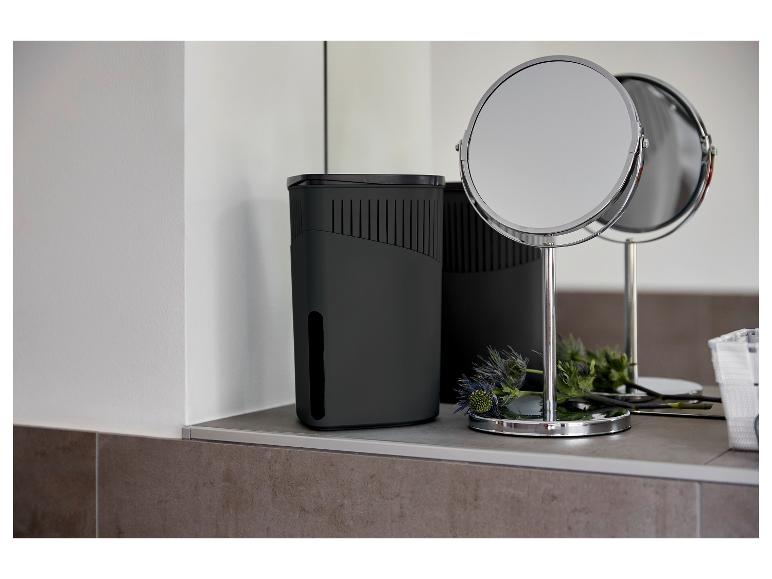 Een zwarte luchtontvochtiger en een tafelspeigel in een moderne badkamer.