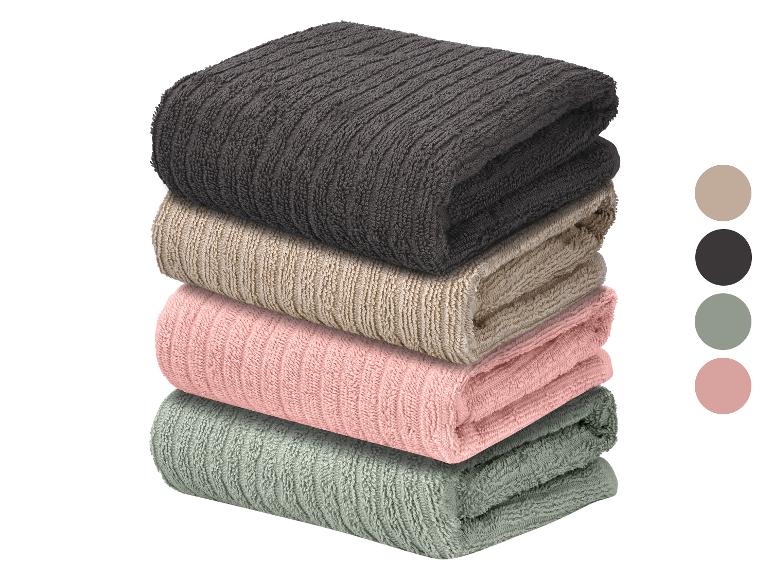 Een stapel van vier gevouwen handdoeken in verschillende kleuren, met kleurstalen ernaast.