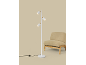 Witte vloerlamp met drie spots naast een beige fauteuil.