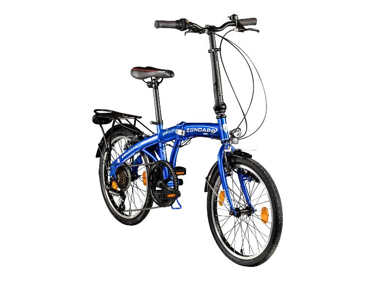 Blauwe vouwfiets met bagagedrager en voorlicht, schuin van voren gefotografeerd.