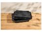 Twee zwarte rechthoekige braadsledes met gespikkeld oppervlak op een houten ondergrond.