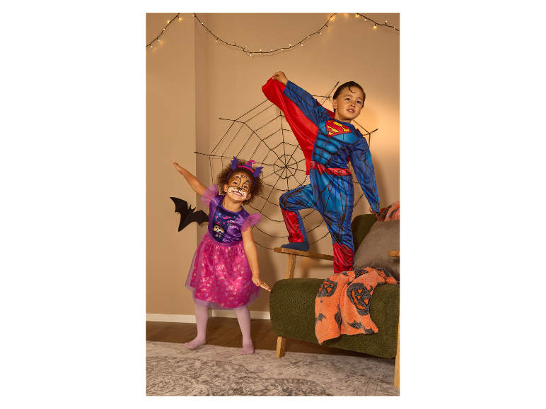 Twee kinderen in Halloweenkostuums: een meisje als kat en een jongen als superheld.