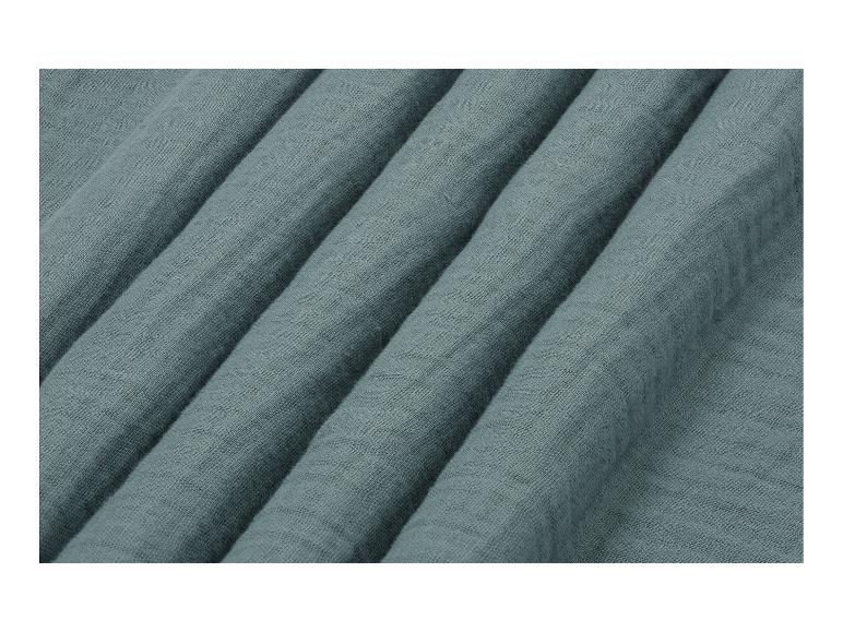Close-up van een teal-kleurige, getextureerde stof met zachte plooien