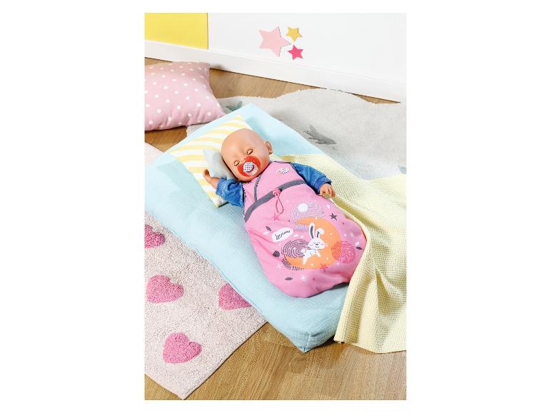 BABY born pop slaapt in roze slaapzak met konijn, op een blauw matras.