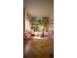 Kinderkamer met huisvormig bed, lezend meisje en bosbehang.