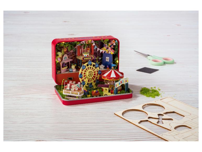 Carnavalsdiorama in een rood metalen blik, met montageaccessoires.