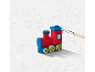 Rood-blauwe speelgoedtrein wordt met een kwast beschilderd op een witte achtergrond.