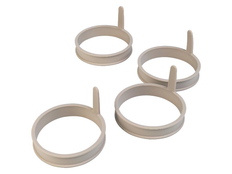 Vier ronde siliconen vormen voor het bakken van eieren.