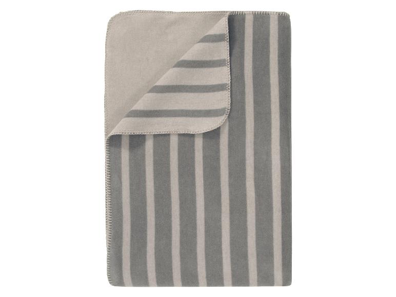 Grijze en witte gestreepte fleece deken.
