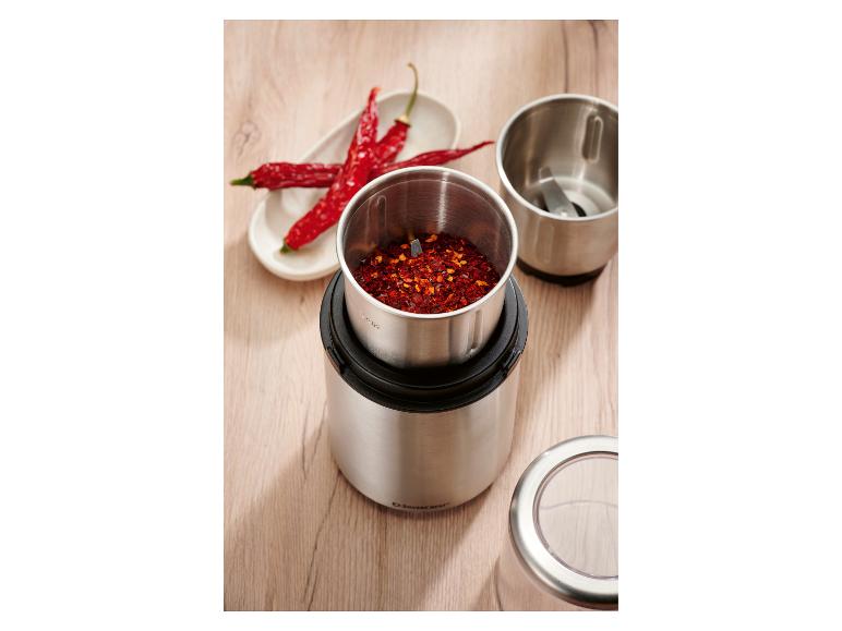 Roestvrijstalen kruidenmolen met chilivlokken en gedroogde rode pepers.