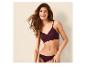 Lachende vrouw in een pruimkleurige bralette en bijpassende slip.
