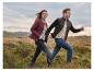 Man en vrouw in de natuur, gekleed in gewatteerde jassen en jeans.