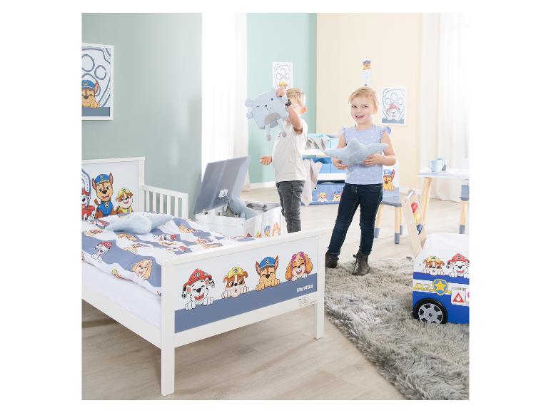 Twee kinderen spelen in een kamer met Paw Patrol-meubels en beddengoed.