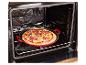 Vers bereide pizza in een rode bakvorm, geplaatst in een open oven.