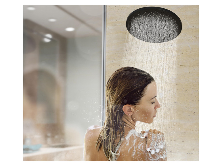 Een vrouw staat onder een grote regendouche.