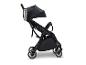 Zwarte kinderwagen met roestvrijstalen bekerhouder op een witte achtergrond.