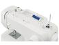 Witte naaimachine met blauwe draad, draadklos en spoelwindsysteem
