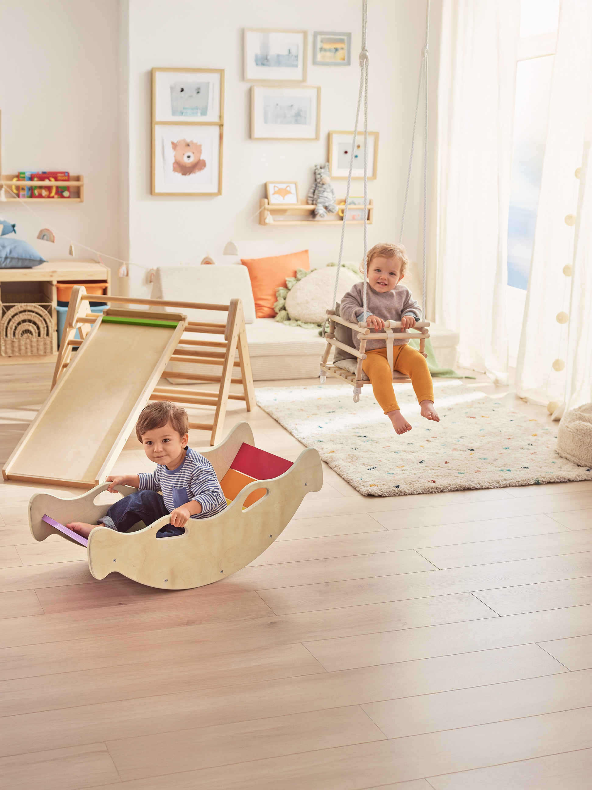 Twee blije peuters spelen met houten speelgoed in een lichte kinderkamer.