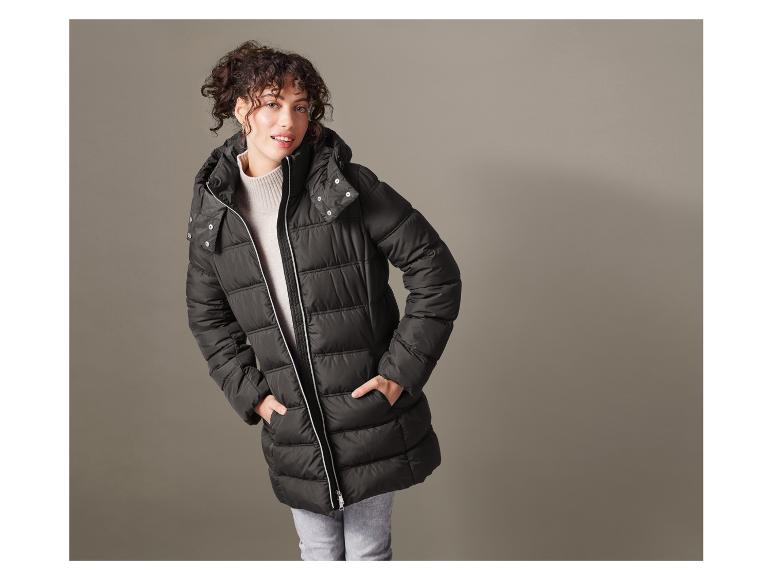Vrouw in een zwarte gewatteerde jas met capuchon.