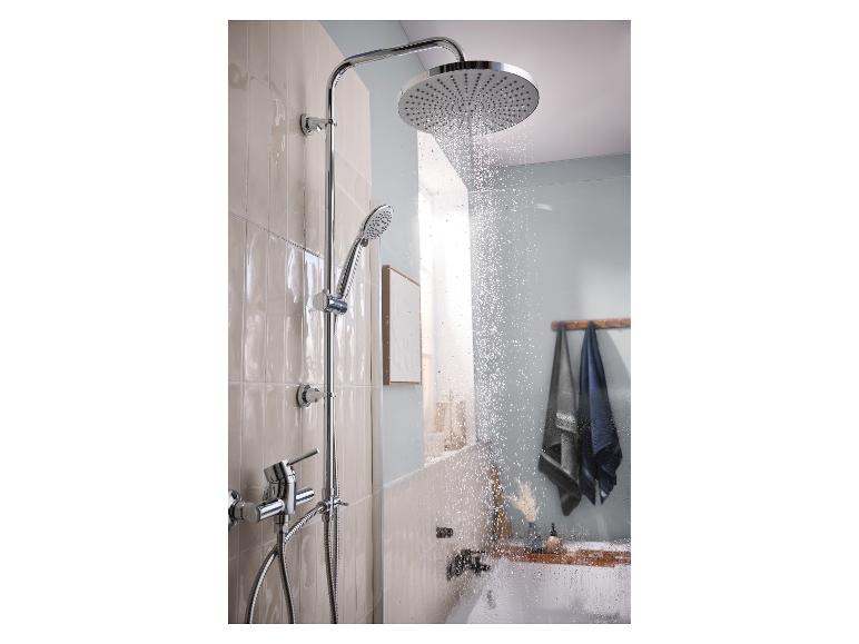 Chromen regendouche met handdouche en kraan in een moderne badkamer.