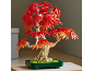 Kunstmatige bonsaiboom met rode en oranje bladeren in een groene pot.
