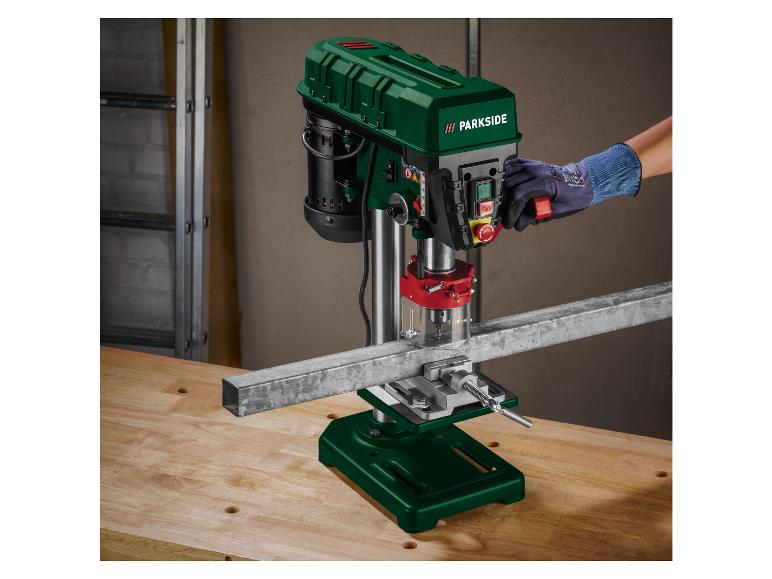 Een groene Parkside boormachine boort een metalen balk.