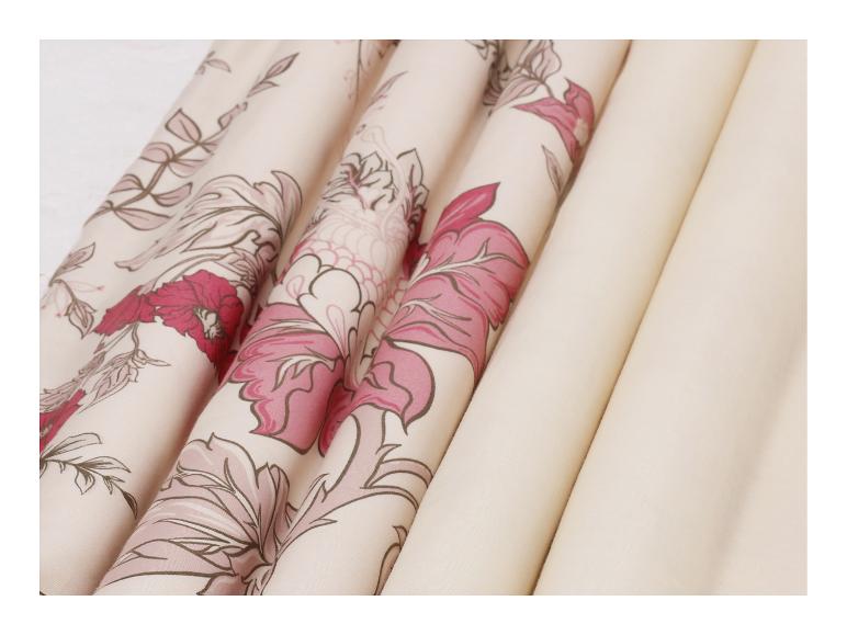 Opgerolde stoffen met bloemenpatroon in roze en crèmekleuren.
