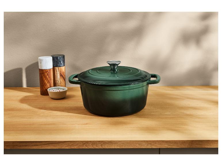 Groene gietijzeren pan op een houten aanrecht.