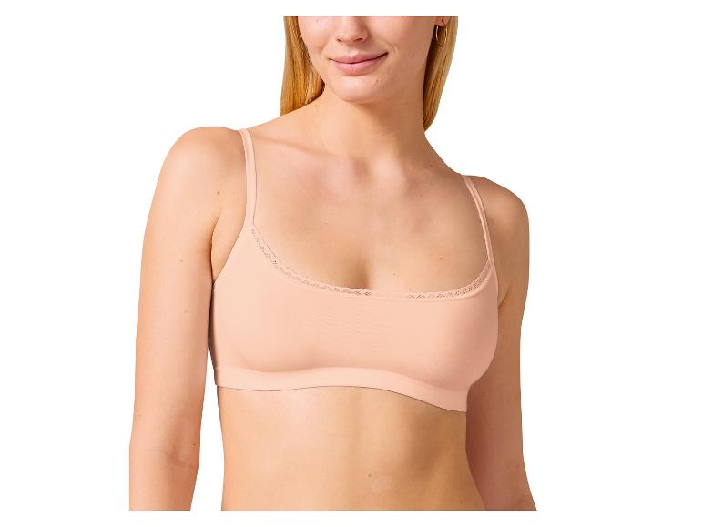 Een vrouw draagt een beige bralette met kant.