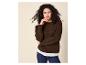 Vrouw in bruine trui en jeans, met krullend haar, poseert met hand aan kin.