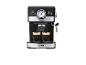 Zwart-zilveren espressomachine die koffie in twee glazen kopjes schenkt.