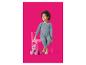 Meisje in blauwe pyjama met strikjes, zittend op een roze stoel met een teddybeer