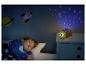 Een kind slaapt in een bed met een schildpad nachtlamp projector die sterren en manen projecteert.