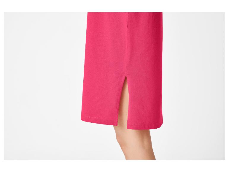 Detail van een fuchsia rok met zijsplit, toont een deel van een been.