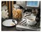 Espressomachine zet koffie, met potten meringues en koekjes, en een bord met een lepel.